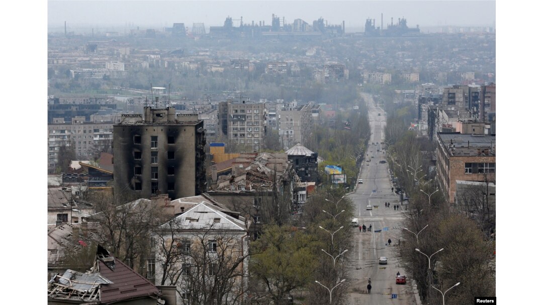 FILE - FILE PHOTO: A view shows damaged buildings, with the Azovstal Iron and Steel Works plant in the background, in the southern port city of Mariupol, Apr. 19, 2022.