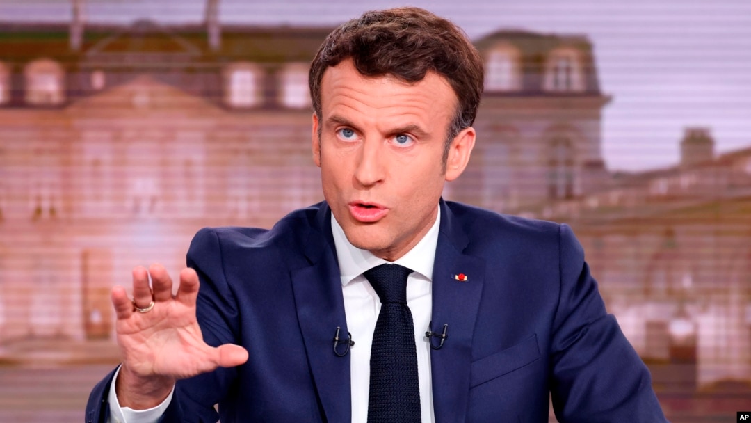 FILE - French President and centrist candidate for reelection Emmanuel Macron gestures during a news broadcast of French TV channel TF1, outside Paris, April 13, 2022.