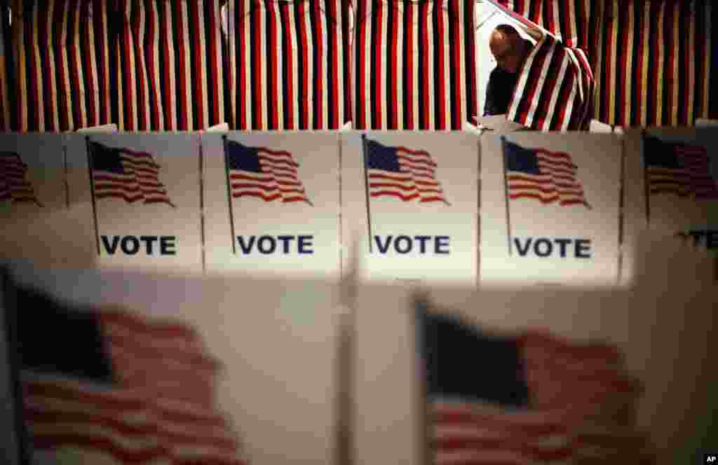 Jim Smith steps out of a voting booth after marking his ballot at a polling site for the New Hampshire primary, Feb. 9, 2016, in Nashua, N.H.