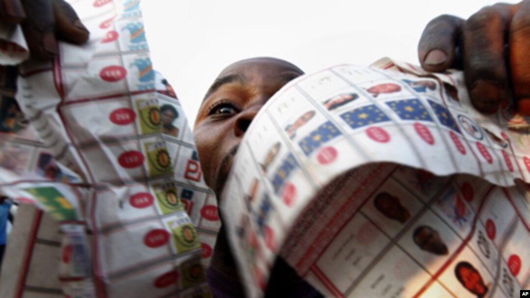 Supporters of oppositions candidate Etienne Tshisekedi parade what they claim are badly printed fraudulent photocopies of election ballots they say they found in the Bandal commune in Kinshasa, Democratic Republic of Congo, Monday Nov. 28, 2011.