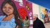 El artista Abel Ortiz muestra al secretario de Justicia de EEUU, Merrick Garland, a la derecha, los murales que recuerdan a las víctimas de la masacre de 2022 en la escuela en Uvalde, Texas, el 17 de enero de 2024. 