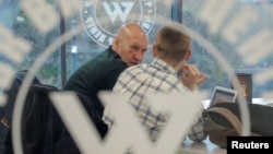 Men speak inside PMC Wagner Center, a project implemented by the businessman and founder of the Wagner private military group Yevgeny Prigozhin, during the official opening of the office block in Saint Petersburg on November 4, 2022. (Igor Russak/Reuters)