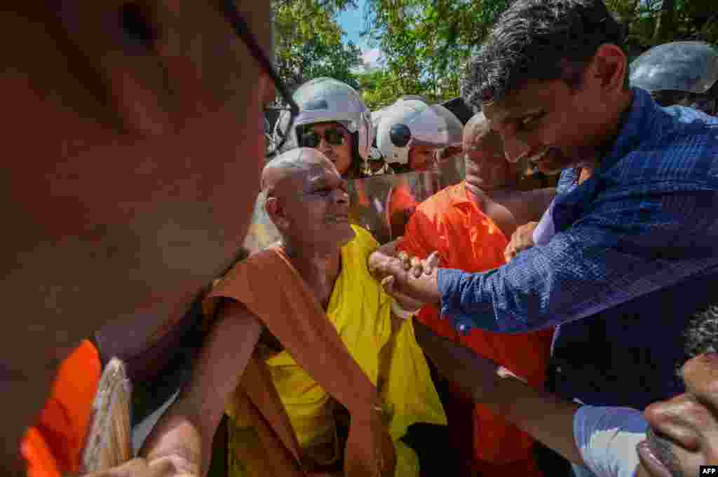 A group of hardline Buddhist monks and anti-government demonstrators scuffle with police near the parliament during a protest against the President Ranil Wickremesinghe's plan to devolve powers to minority Tamils, in Colombo.