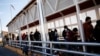 FILE - Migrants expelled from the U.S. and sent back to Mexico under Title 42 walk towards Mexico at the Paso del Norte International border bridge, in Ciudad Juarez, Mexico, April 1, 2022.