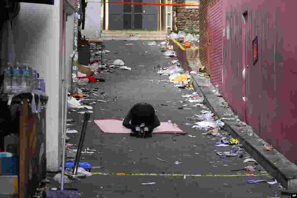 A man bows in the middle of the scene of a deadly accident following Saturday night's Halloween festivities in Seoul, South Korea. A crowd surge killed more than 150 people in one of the country’s worst disasters in years.