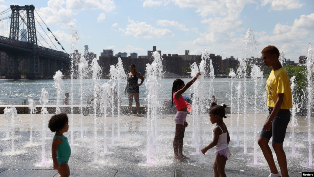 Grupo de personas se refrescan en fuentes públicas durante una ola de calor en Brooklyn, Nueva York, el 8 de agosto de 2022.