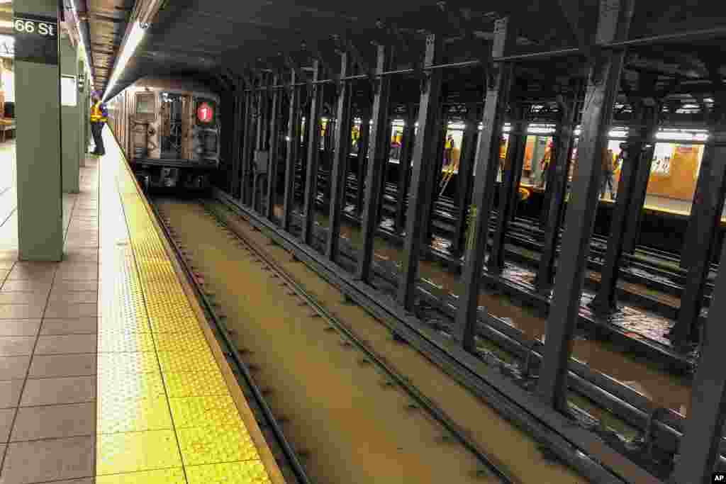 A subway train sits on flooded tracks at 66th Street in New York. A water main break flooded streets on Manhattan's Upper West Side near Lincoln Center and hampered subway service during the Monday morning rush hour.