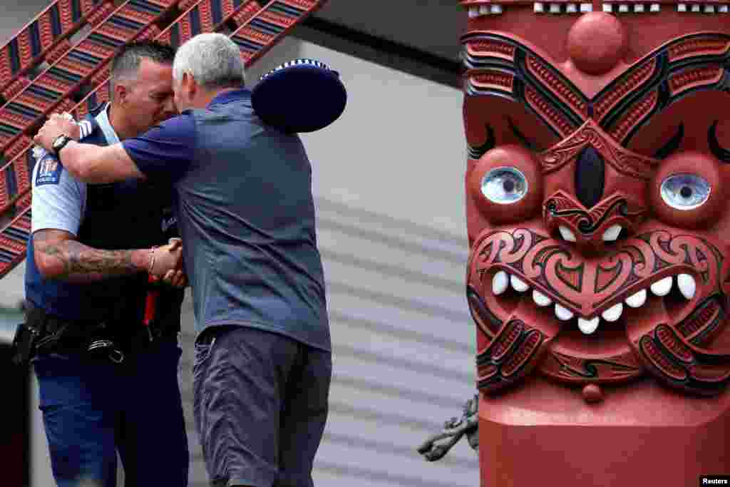 A police officer and a man perform a Hongi after a ceremony called "Karakia", attended by Ngati Awa representatives and relatives of the volcano eruption victims at Mataatua Marae house in Whakatane, New Zealand.
