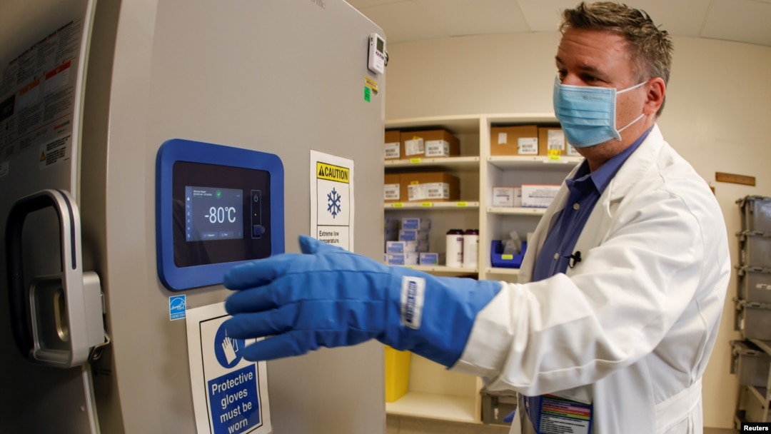 ARHIVA - Farmaceut u Los Anđelesu ispred specijalnog frižidera za čuvanje Fajzer vakcina na temperaturi od -80 stepeni Celzijusa (Foto: Reuters)
