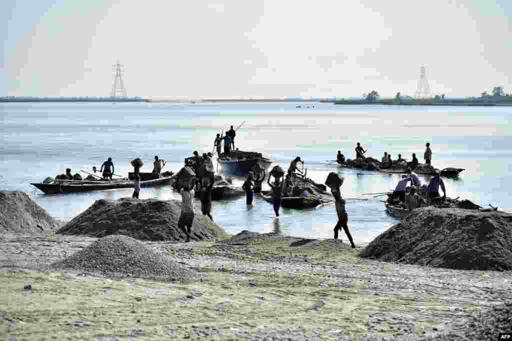 Laborers extract sand from the riverbed of the Beki River in the district of Barpeta of the northern Indian state of Assam.