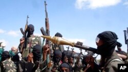 FILE - Armed al-Shabab fighters ride on pickup trucks as they prepare to travel into the city, just outside the capital Mogadishu, Dec. 8, 2008.