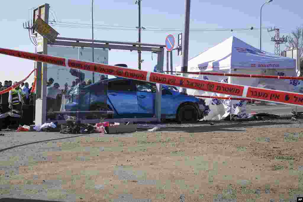 Members of Zaka Rescue and Recovery team and Israeli police forensic team work at the site of a deadly car-ramming attack at a bus stop in Ramot, a Jewish settlement in east Jerusalem.