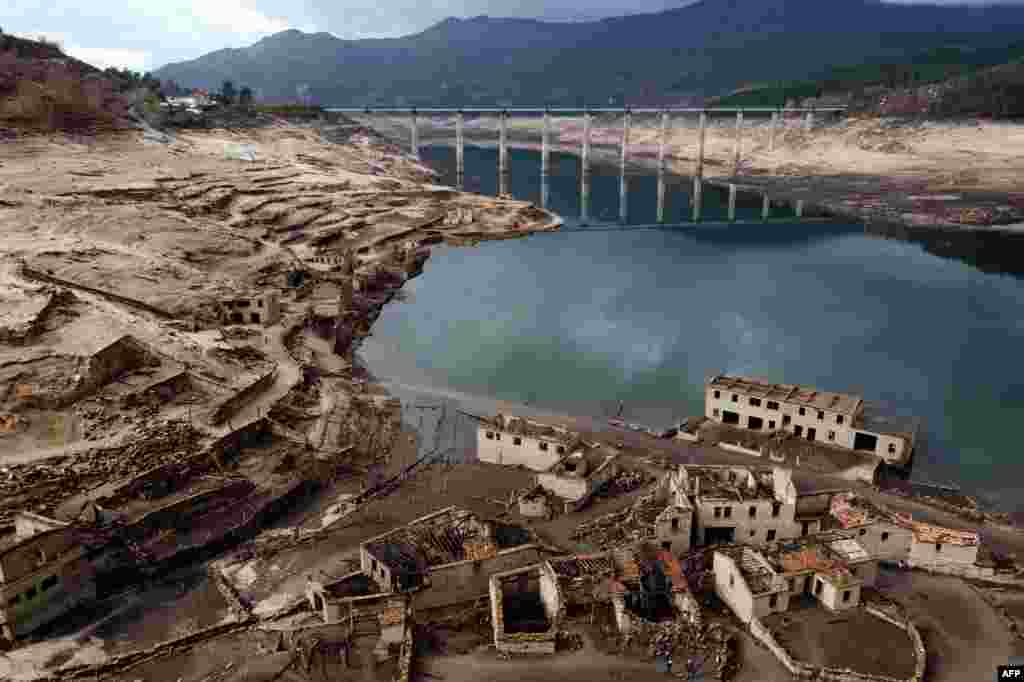 This photograph shows an aerial view of the usually submerged ruins of the former village of Aceredo, appearing from the Lindoso hydroelectric plant reservoir due to the low water level, near Lobios, Ourense province, northwestern Spain, Feb. 15, 2022. People living in the Aceredo village were evicted from their homes in 1992 for the construction of the reservoir.