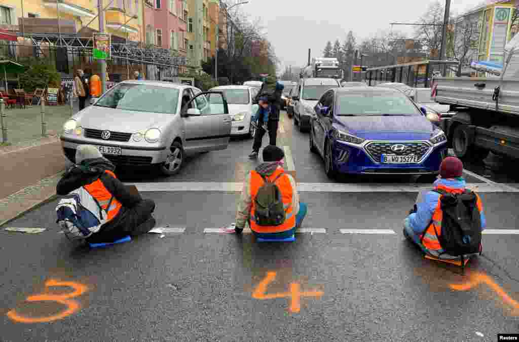 Climate-change activists of "Letzte Generation" (Last Generation) sit glued to a road to block traffic during morning rush hour in Berlin, Germany, Nov. 21, 2022.