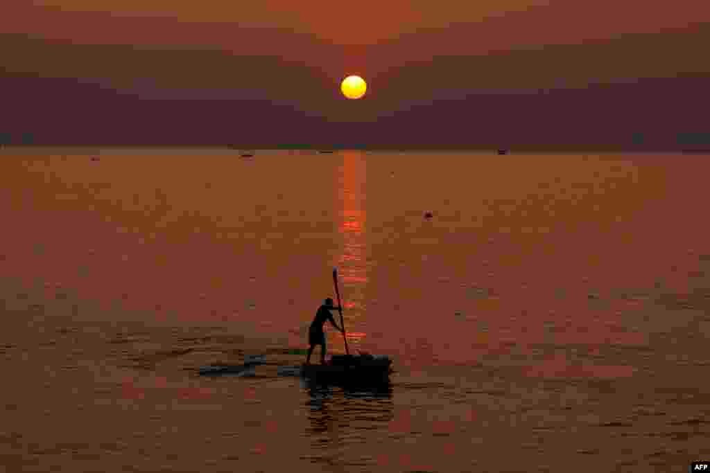 A Palestinian man rows a boat at sunset off the coast of Gaza City.