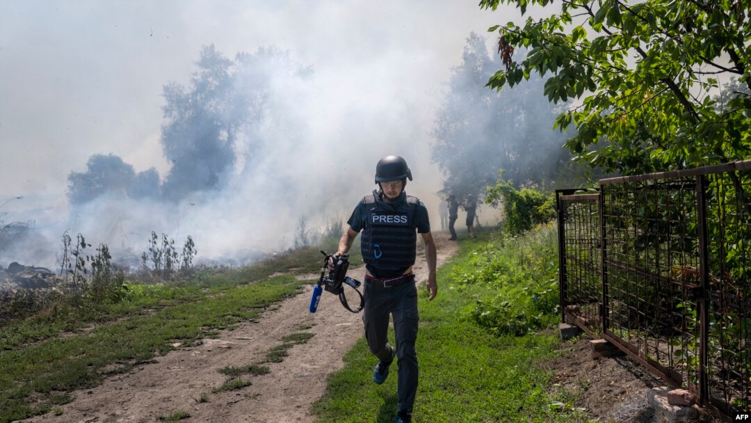 Novinar AFP-a trči dok se dim diže iza njega posle bombardovanja Bahmuta, istočna Ukrajina, 3. jul 2022. (Foto: AFP/Bulent Kilic)