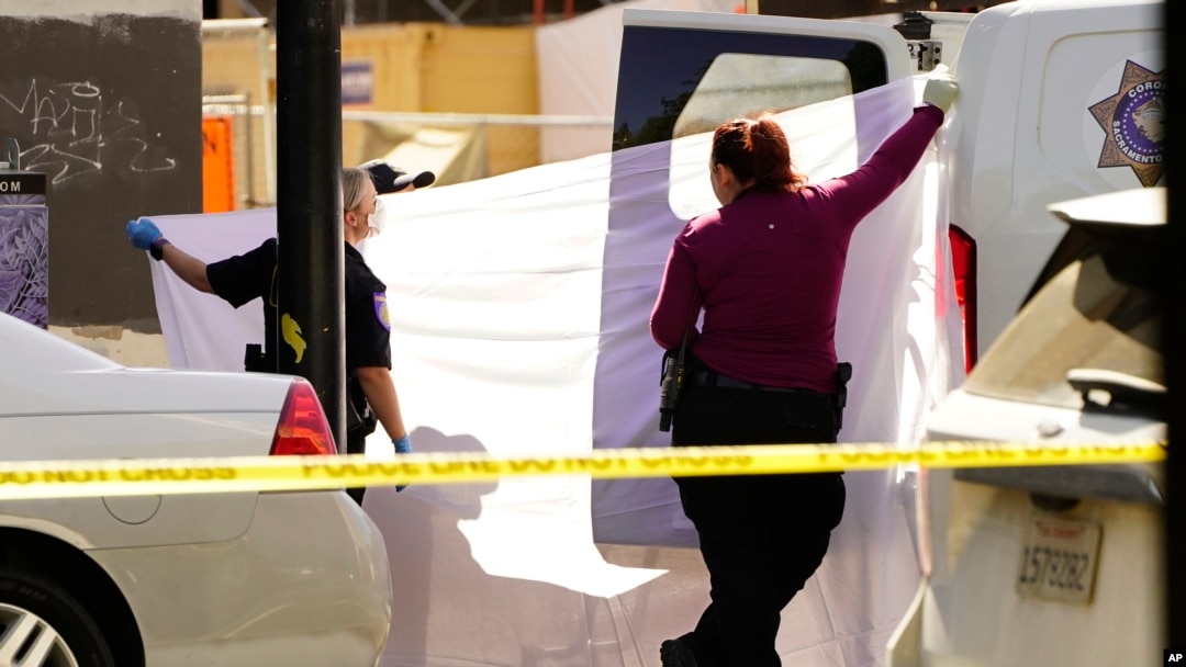 Se usa una sábana para bloquear la vista mientras el cuerpo de una de las víctimas asesinadas en un tiroteo masivo se carga en una camioneta forense en Sacramento, California, el 3 de abril de 2022. (Foto AP / Rich Pedroncelli)