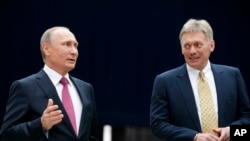 Phát ngôn nhân Điện Kremlin Dmitry Peskov ở bên trái Tổng thống Nga Vladimir Putin