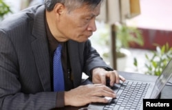 Tiến sĩ Nguyễn Quang A viết một bình luận trên Facebook trong khi ngồi ở quán cà phê sau cuộc phỏng vấn ở Hà Nội, Việt Nam, ngày 1 tháng 3 năm 2016.