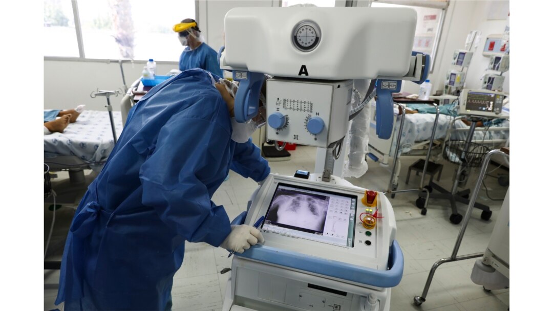 A healthcare worker wearing full protective gear looks at the chest X-ray of a patient in a ward reserved for COVID-19 patients at the Hospital Juarez, in Mexico City, June 26, 2020.