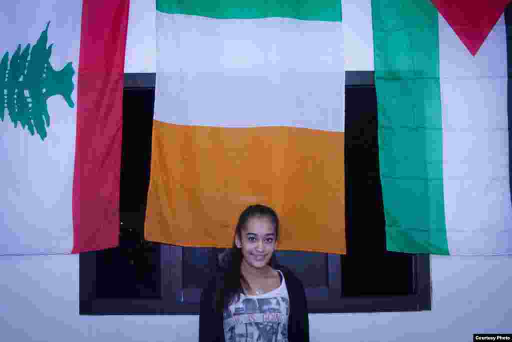 Gulizar Osman, who plays for the girls basketball team, stands in front of the flag of Ireland because supporters who help fund the team are from Ireland. Coach Majdi calls them "the Irish delegation." (John Owens/VOA)