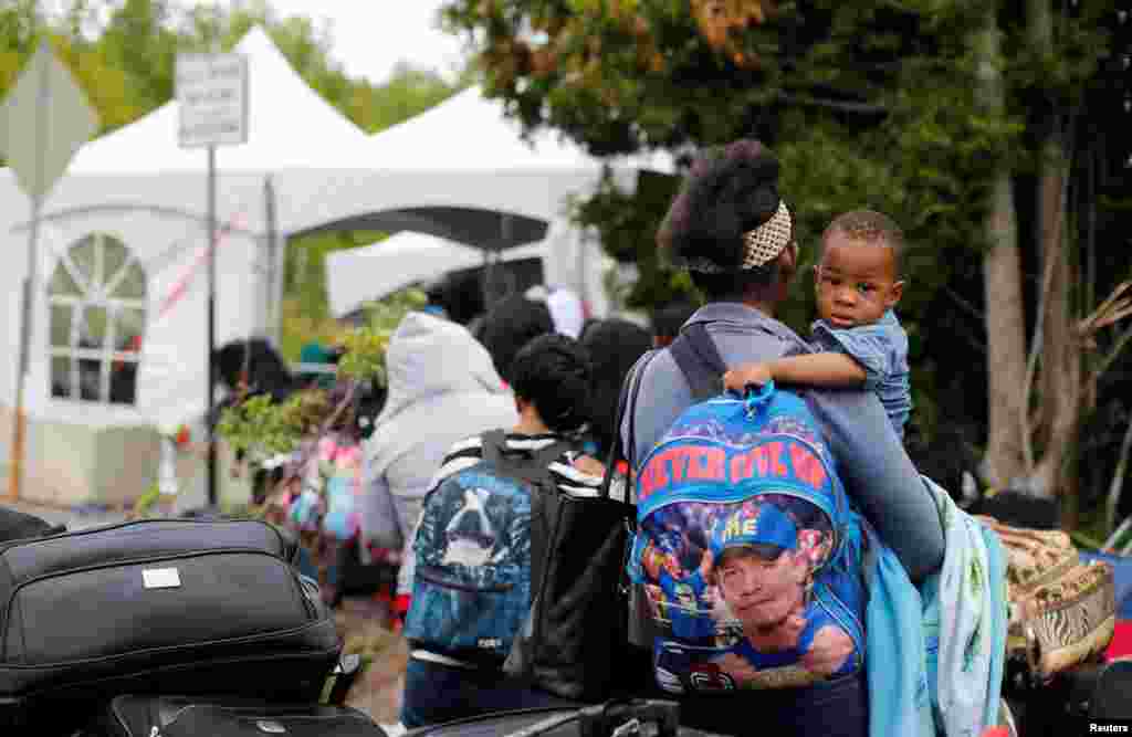 A line of asylum seekers who said they were from Haiti wait to enter into Canada from Roxham Road in Champlain, New York, Aug. 7, 2017.