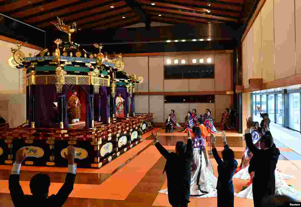 Japan's Prime Minister Shinzo Abe (R) shouts "banzai", as he cheers for Emperor Naruhito (top L) and Empress Masako at a ceremony to proclaim the emperor's enthronement to the world, called Sokuirei-Seiden-no-gi, at the Imperial Palace in Tokyo.