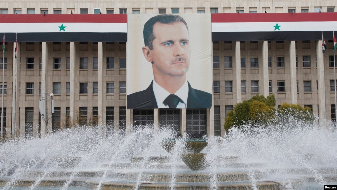 FILE - A picture of the Syria's President Bashar Assad is seen on the central bank building in Damascus, Feb. 24, 2012. 