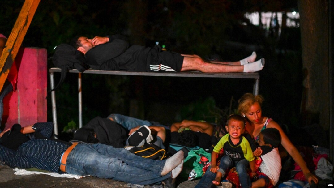 Una mujer sentada con un niño llorando mientras migrantes hondureños, parte de una caravana que se dirige a Estados Unidos, descansan en Entre Ríos, Guatemala, luego de cruzar la frontera desde Honduras el 1 de octubre de 2020.