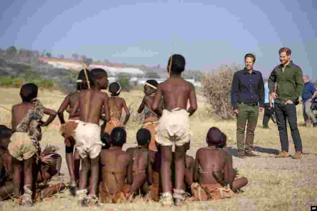 Britain's Prince Harry, right, and Elephants Without Borders founder Mike Chase are welcomed at a tree planting event with local schoolchildren, at the Chobe Tree Reserve, in Botswana.