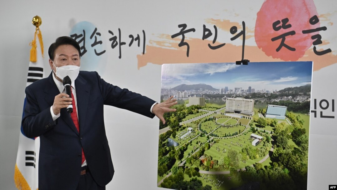 FILE - South Korea's president-elect Yoon Suk-yeol shows a bird's eye view of his planned relocation of the presidential office during a press conference at his transition team office in Seoul on March 20, 2022. 