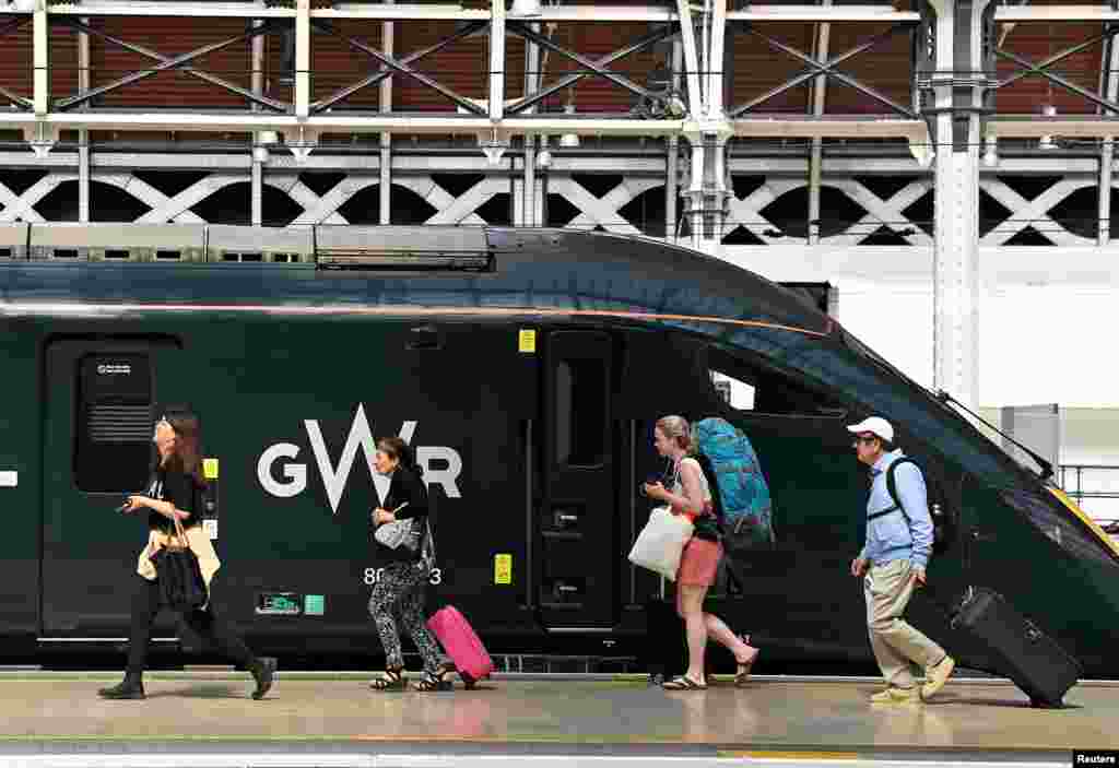 Passengers board a train bound for the west of England, ahead of a planned national strike by rail workers, at Paddington Station, in London.
