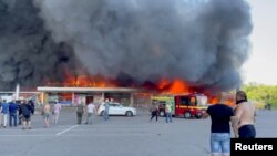 FILE - Smoke rises from a shopping mall hit by a Russian missile in Kremenchuk, Ukraine, June 27, 2022. Ukraine reported a Russian missile strike Tuesday in Kremenchuk, a year to the day after the strike that hit the mall. (Telegram/Handout via Reuters)