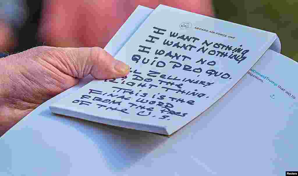 U.S. President Donald Trump reads from his notes as he speaks to reporters on the South Lawn of the White House in Washington before departing for Austin, Texas.