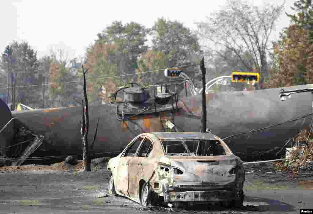 A burnt out vehicle sits near the wreckage of a train car after a train derailment in Lac-Megantic, Quebec, July 7, 2013.
