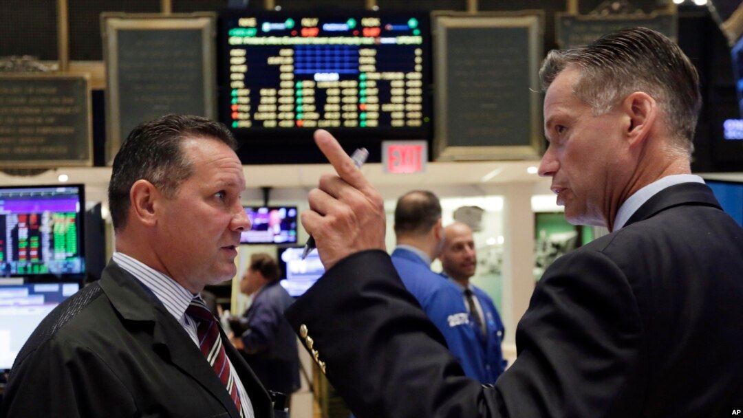 Traders on the floor of the New York Stock Exchange react to market changes, Aug. 25, 2015.