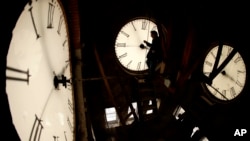 ARCHIVO - El conserje Ray Keen inspecciona la esfera de un reloj de 100 años de antigüedad que se encuentra en la cima del Palacio de Justicia del condado de Clay, el 8 de marzo de 2014, en Clay Center, Kansas. (Foto AP/Charlie Riedel)