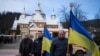 Personas sostienen banderas ucranianas durante la ceremonia fúnebre de los asesinados Vasyl Medviychuk y Dmytro Dosiak en las oficinas del ejército ucraniano en Verkhovyna, Ucrania, el jueves 28 de diciembre de 2023. (Foto: Archivo/AP)
