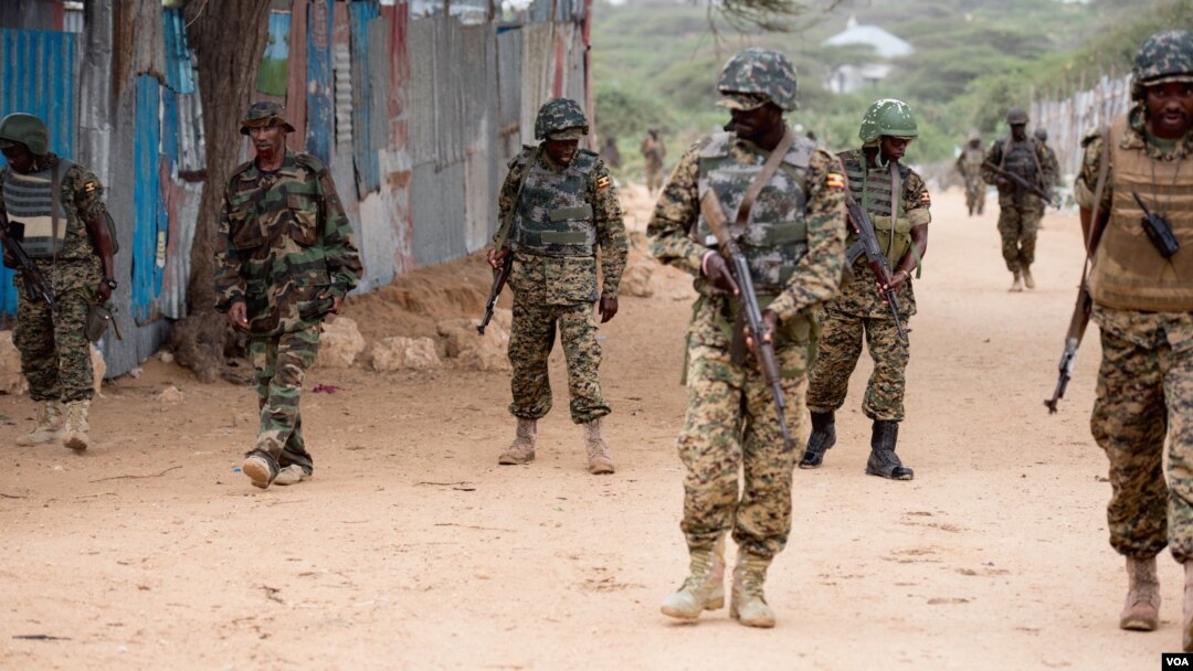 FILE - AMISOM soldiers and armored vehicles pass a woman riding a cart during a patrol at a village outside Mogadishu, Sept. 19, 2016. (Photo: J. Patinkin/VOA)