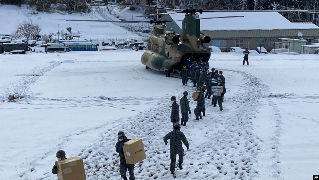 In this photo provided by Japanese Ministry of Defense, members of Japan Self-Defense Forces carry relief goods in the earthquake-hit city Wajima, Ishikawa prefecture, Japan, Jan. 8, 2024.
