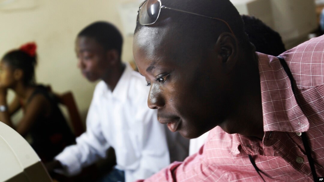 FILE - Momulu Norman, 22, a former child soldier, teaches at a computer school in Monrovia, Liberia.
