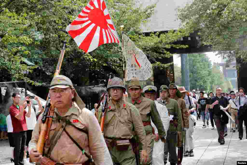 Men wearing Japanese imperial military uniform visit the Yasukuni Shrine in Tokyo, Japan, on the 74th anniversary of the country's surrender in World War II.