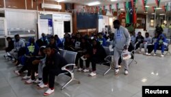 FILE - Guinean migrants wait at the airport before being deported to Guinea, in Misrata, Libya, Dec. 27, 2017.