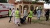 FILE - Rescue workers remove a body after a suicide attack at a camp of people displaced by Islamist extremists in Maiduguri, Nigeria, July 24, 2017. Female suicide bombers attacked two displaced persons camps in northeastern Nigeria's main city.