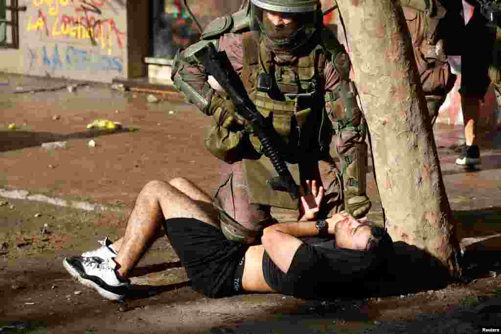 A policeman detains a demonstrator during a protest against Chile's government in Santiago, Chile, Nov. 13, 2019.
