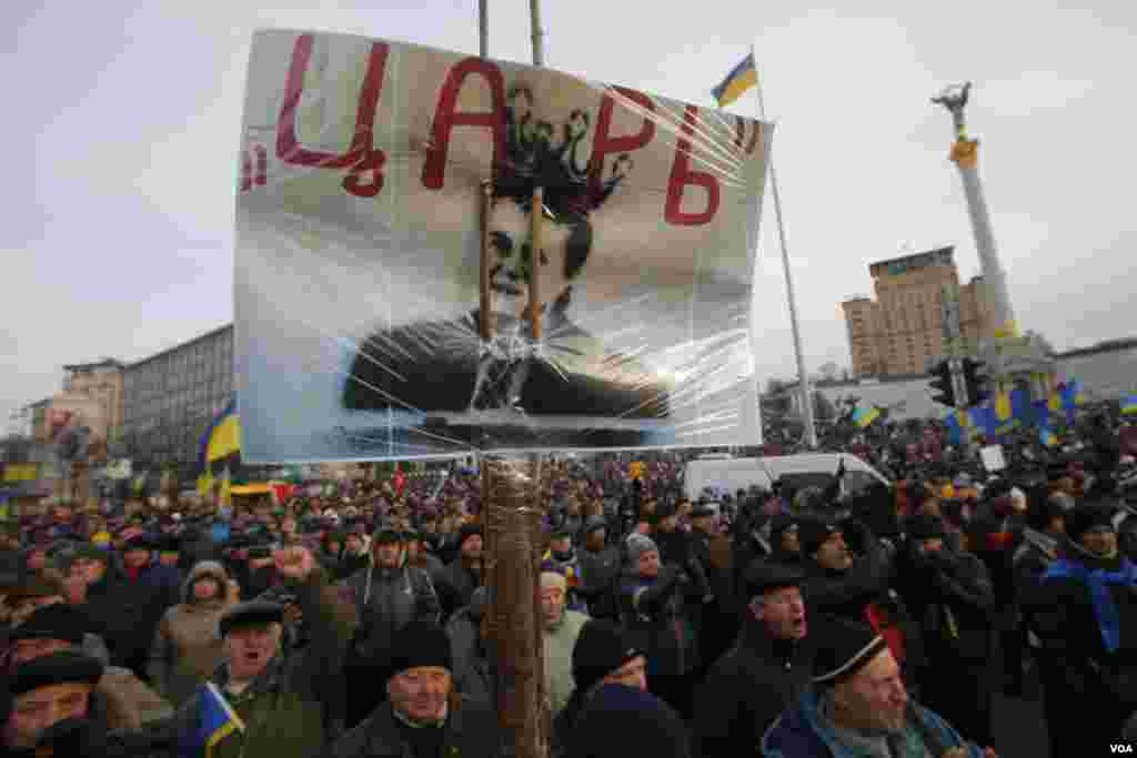 Người biểu tình xuống đường cầm biểu ngữ và hình Tổng thống Ukraina Viktor Yanukovych với hàng chữ "Sa hoàng" tại Quảng trường Độc lập ở Kiev, ngày 3/12/2013.