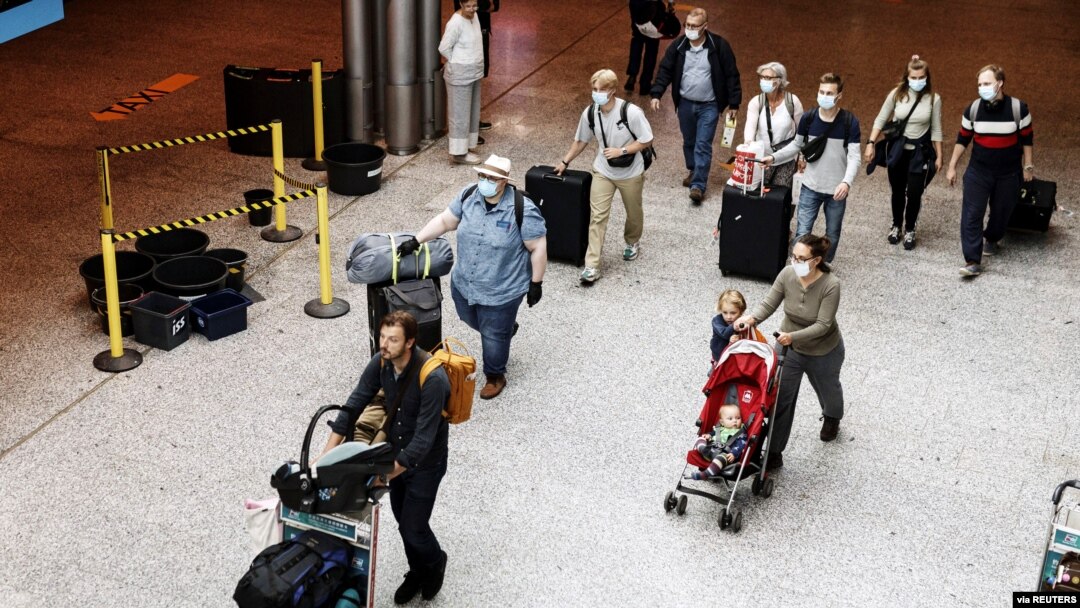 Passengers wearing face masks walk at the Helsinki-Vantaa airport in Vantaa, as Finnish Government has eased travel restrictions with several EU countries following the coronavirus disease (COVID-19) outbreak, in Finland, July 13 2020. 