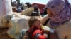 Người Syria tỵ nạn cho con uống sữa tại một cửa khẩu biên giới gần Suruc, Thổ Nhĩ Kỳ.
