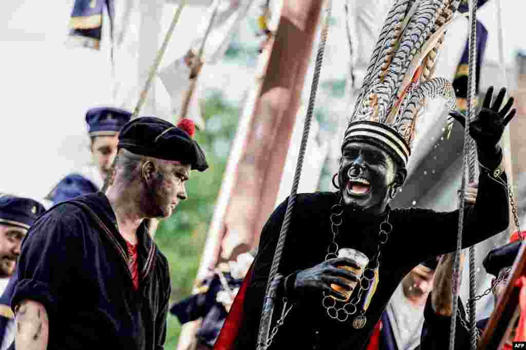 A man wearing a controversial makeup coloring blackface and called "the savage" gestures during a folk parade "Ducasse" of Ath in Ath, Belgium.