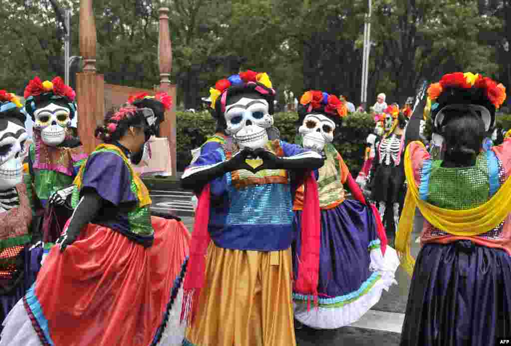 People take part in the Day of the Dead parade along Reforma avenue in Mexico City, Oct. 27, 2019.